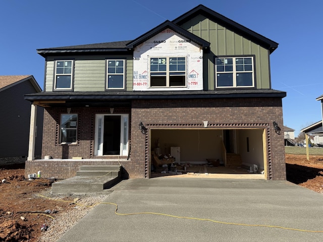 view of front facade featuring board and batten siding, concrete driveway, brick siding, and a garage