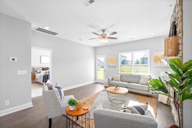 living room featuring ceiling fan and dark hardwood / wood-style flooring