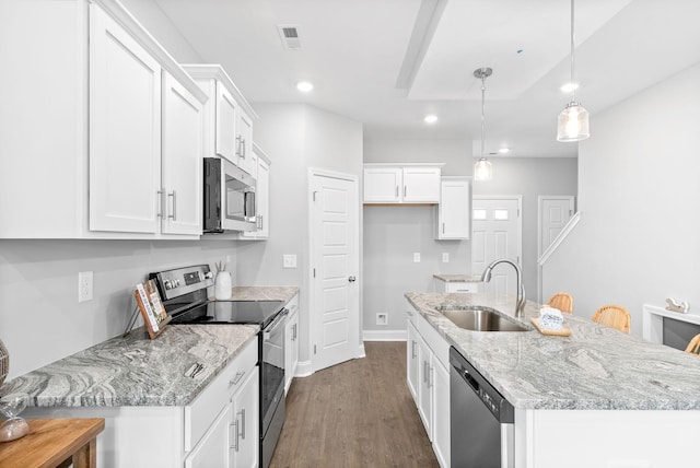 kitchen featuring sink, white cabinets, stainless steel appliances, and decorative light fixtures