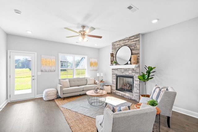 living room with ceiling fan, a fireplace, and dark wood-type flooring