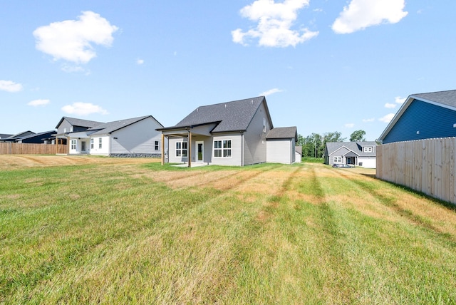 rear view of property featuring a yard