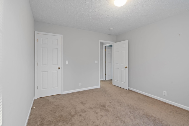 spare room with light carpet and a textured ceiling