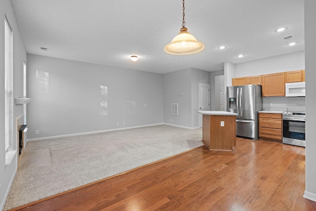 kitchen with pendant lighting, light hardwood / wood-style floors, stainless steel appliances, and a textured ceiling