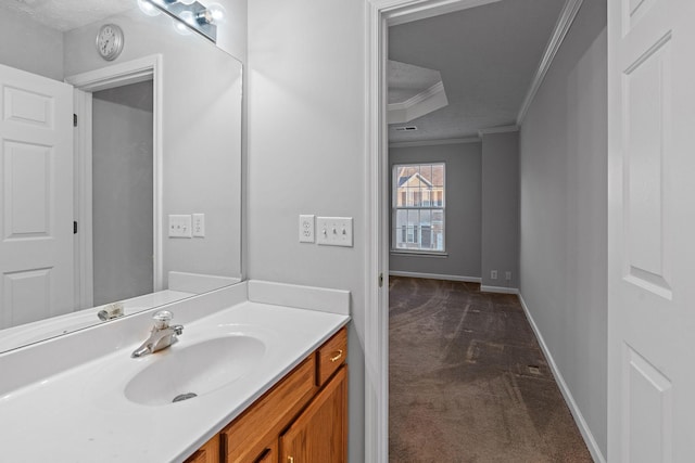 bathroom featuring vanity, a tray ceiling, and crown molding