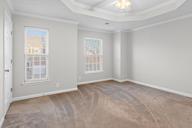 empty room with carpet flooring, a tray ceiling, ceiling fan, and ornamental molding