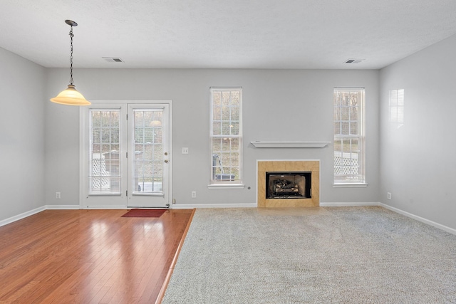 unfurnished living room featuring a tiled fireplace