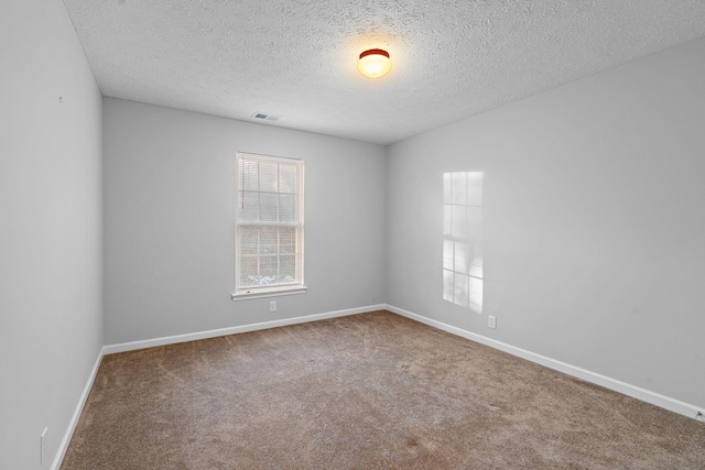 unfurnished room with carpet and a textured ceiling