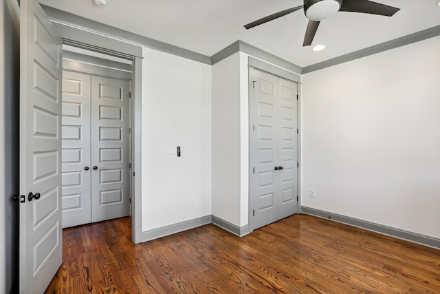 unfurnished bedroom with ceiling fan, a closet, and dark wood-type flooring