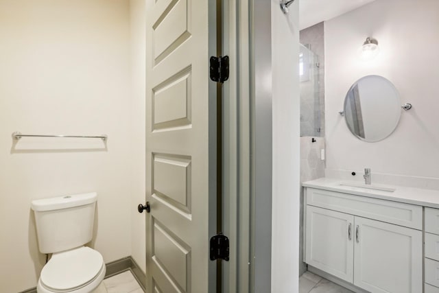 bathroom with vanity, toilet, and a tile shower