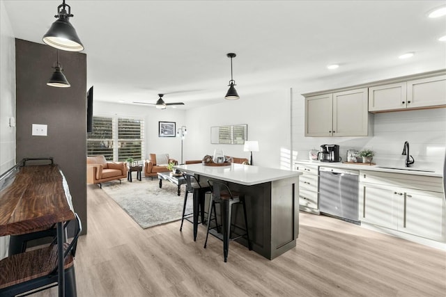 kitchen with stainless steel dishwasher, a center island, pendant lighting, and ceiling fan