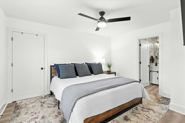 bedroom with connected bathroom, ceiling fan, and hardwood / wood-style floors