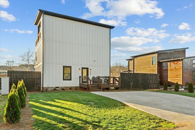 back of property with a lawn and a wooden deck