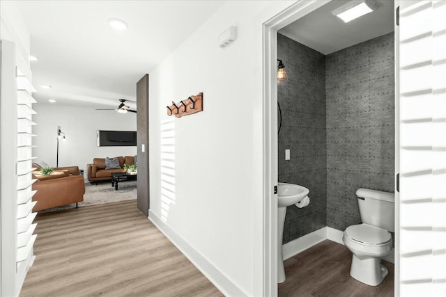 bathroom featuring wood-type flooring, toilet, and ceiling fan