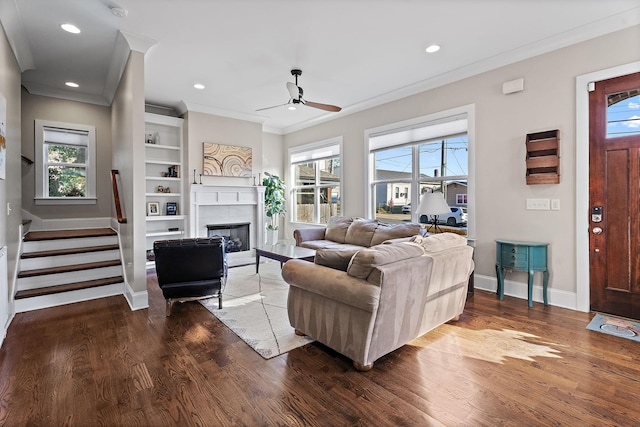 living room featuring a wealth of natural light, ceiling fan, crown molding, and wood-type flooring