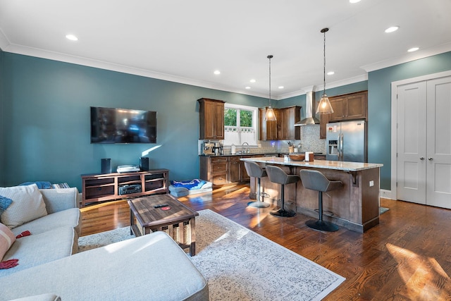 living room with crown molding, sink, and dark hardwood / wood-style floors