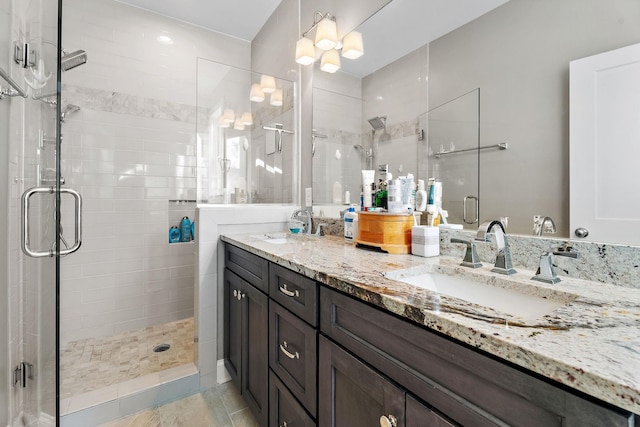 bathroom with tile patterned floors, a shower with door, and vanity