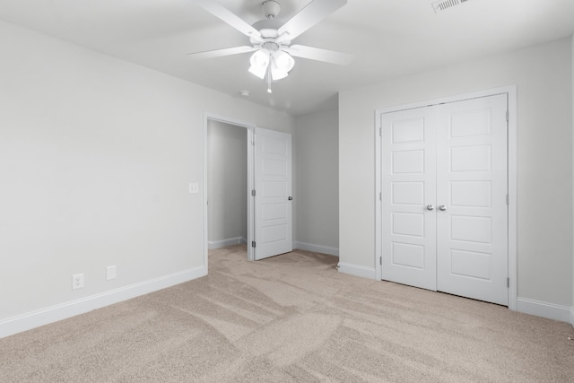 unfurnished bedroom featuring ceiling fan, a closet, and light colored carpet