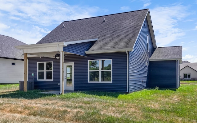 rear view of house featuring ceiling fan and a yard