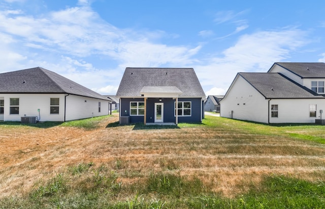 rear view of property with a yard and central AC unit