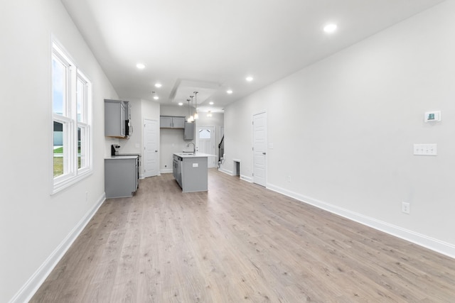 unfurnished living room with sink and light wood-type flooring