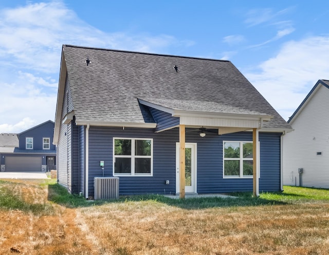 back of property featuring a lawn and central AC