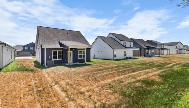 rear view of property featuring central AC and a yard