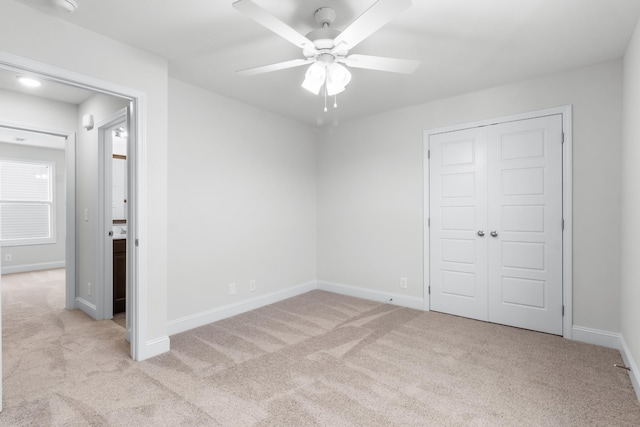 unfurnished bedroom featuring a closet, light colored carpet, and ceiling fan