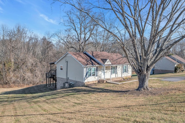 view of front of house with a front lawn and central air condition unit