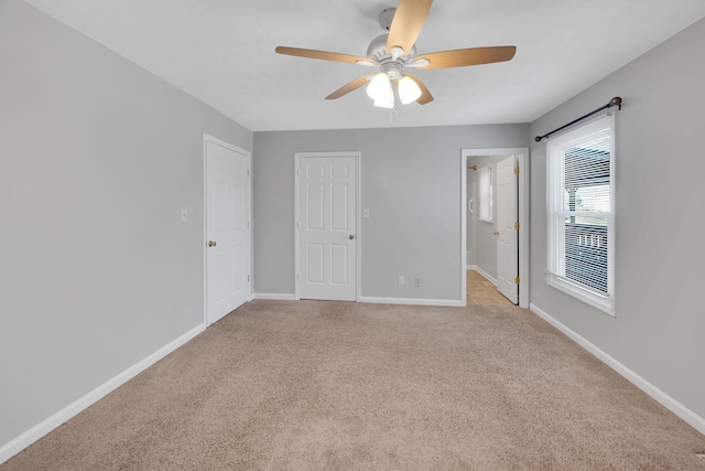 unfurnished room featuring light carpet and ceiling fan