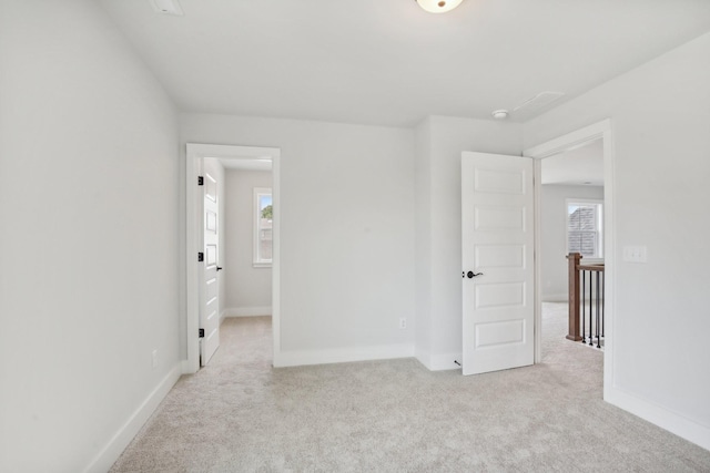 empty room featuring a healthy amount of sunlight and light colored carpet