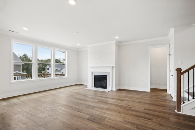 unfurnished living room with a high end fireplace, hardwood / wood-style flooring, and crown molding