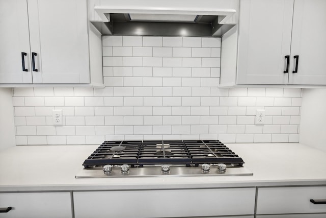 kitchen featuring white cabinets, stainless steel gas stovetop, premium range hood, and tasteful backsplash