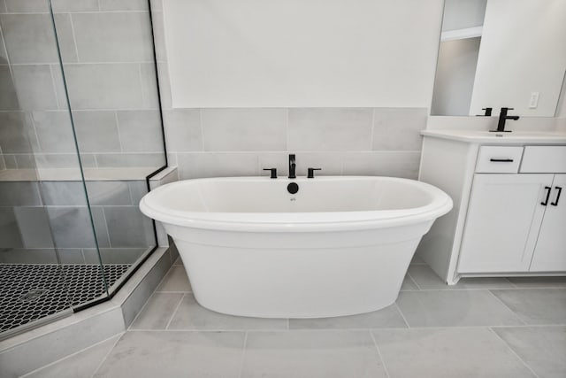 bathroom featuring separate shower and tub, tile patterned flooring, vanity, and tile walls