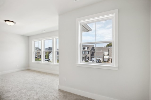 carpeted spare room with a healthy amount of sunlight