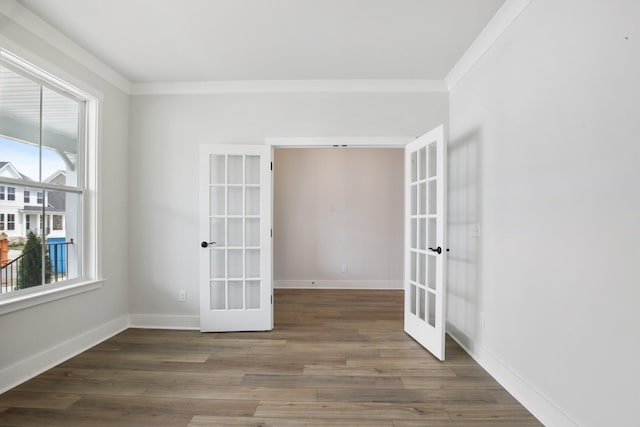 empty room featuring dark hardwood / wood-style floors, ornamental molding, and french doors