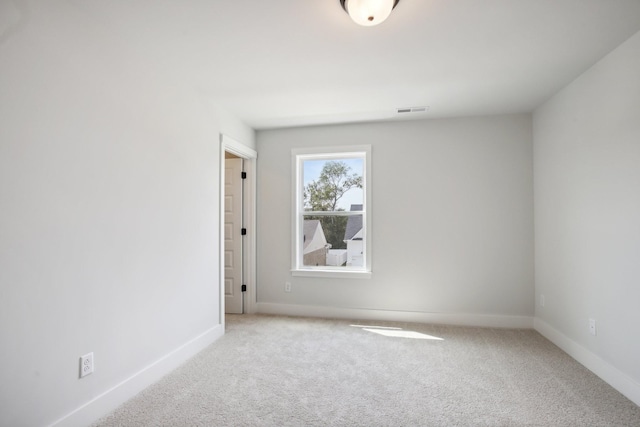 unfurnished room featuring light carpet