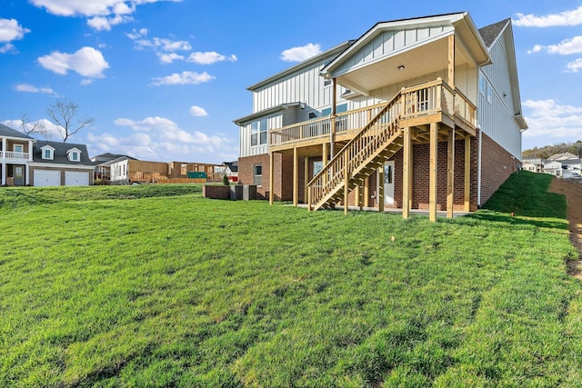 rear view of property featuring a lawn and a wooden deck