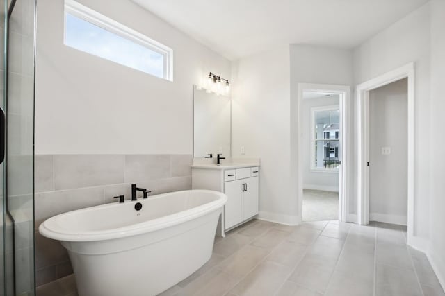 bathroom featuring tile patterned flooring, vanity, and a bathing tub