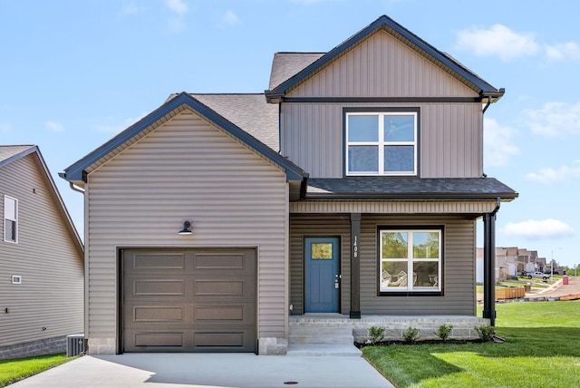 view of front of house with a front yard, a garage, and cooling unit