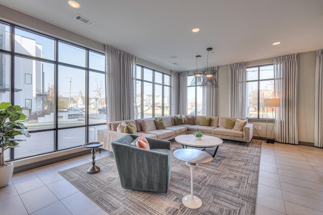 living room with a chandelier and light tile patterned flooring