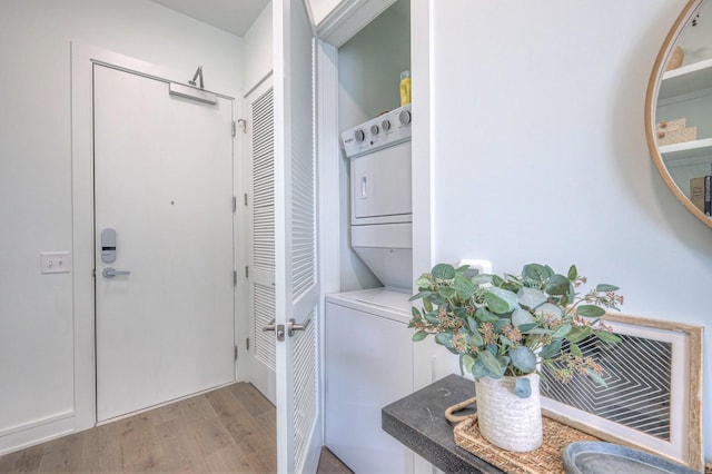 doorway featuring light wood-type flooring and stacked washer / dryer