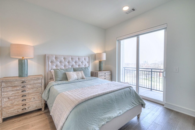 bedroom featuring wood-type flooring and access to outside