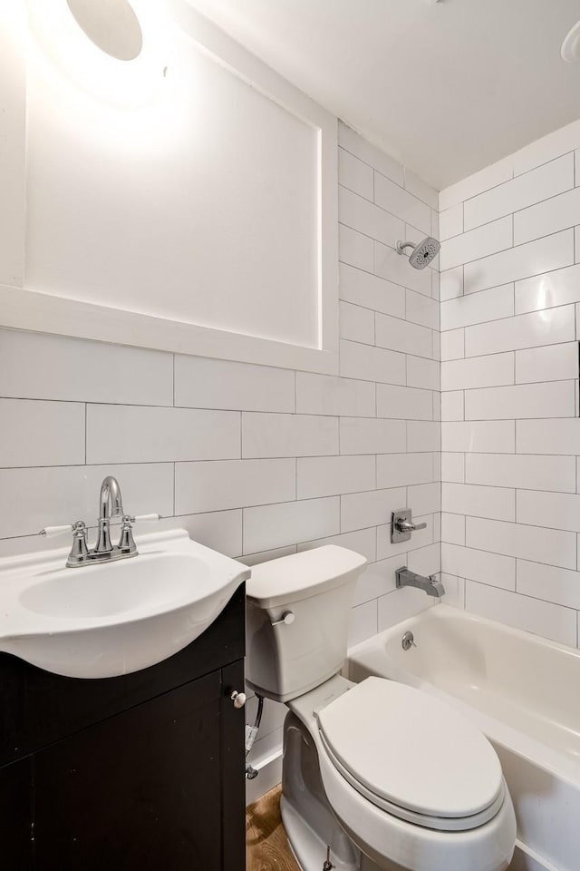 full bathroom with hardwood / wood-style floors, vanity, toilet, and tiled shower / bath