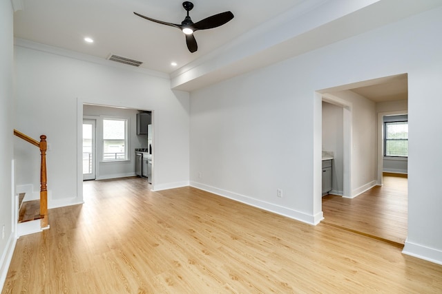 unfurnished living room with ceiling fan, crown molding, and light hardwood / wood-style flooring