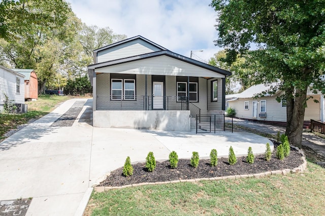 bungalow-style house featuring covered porch and central air condition unit