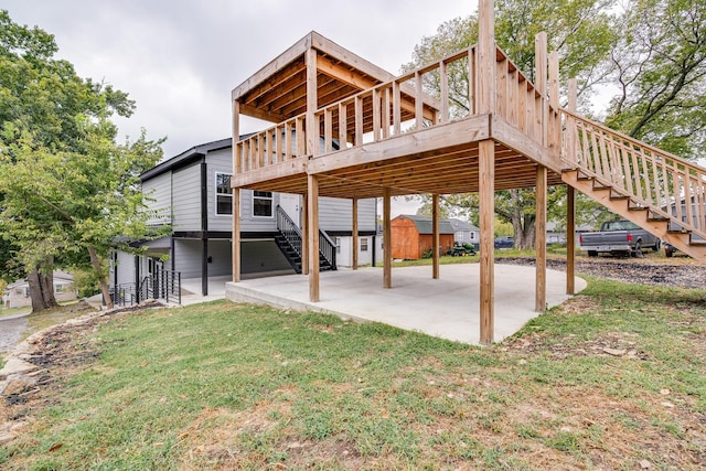 exterior space featuring a lawn, a patio area, a deck, and a shed