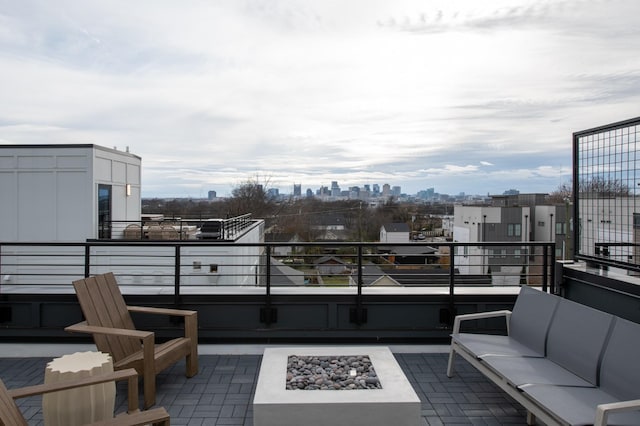 view of patio with a balcony and an outdoor living space with a fire pit