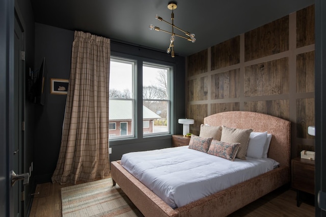 bedroom with wood-type flooring and a chandelier