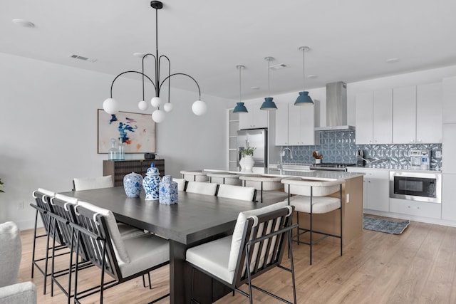 dining area featuring light wood-type flooring and an inviting chandelier