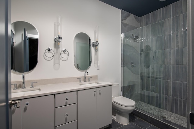 bathroom with tile patterned flooring, vanity, a shower with shower door, and toilet